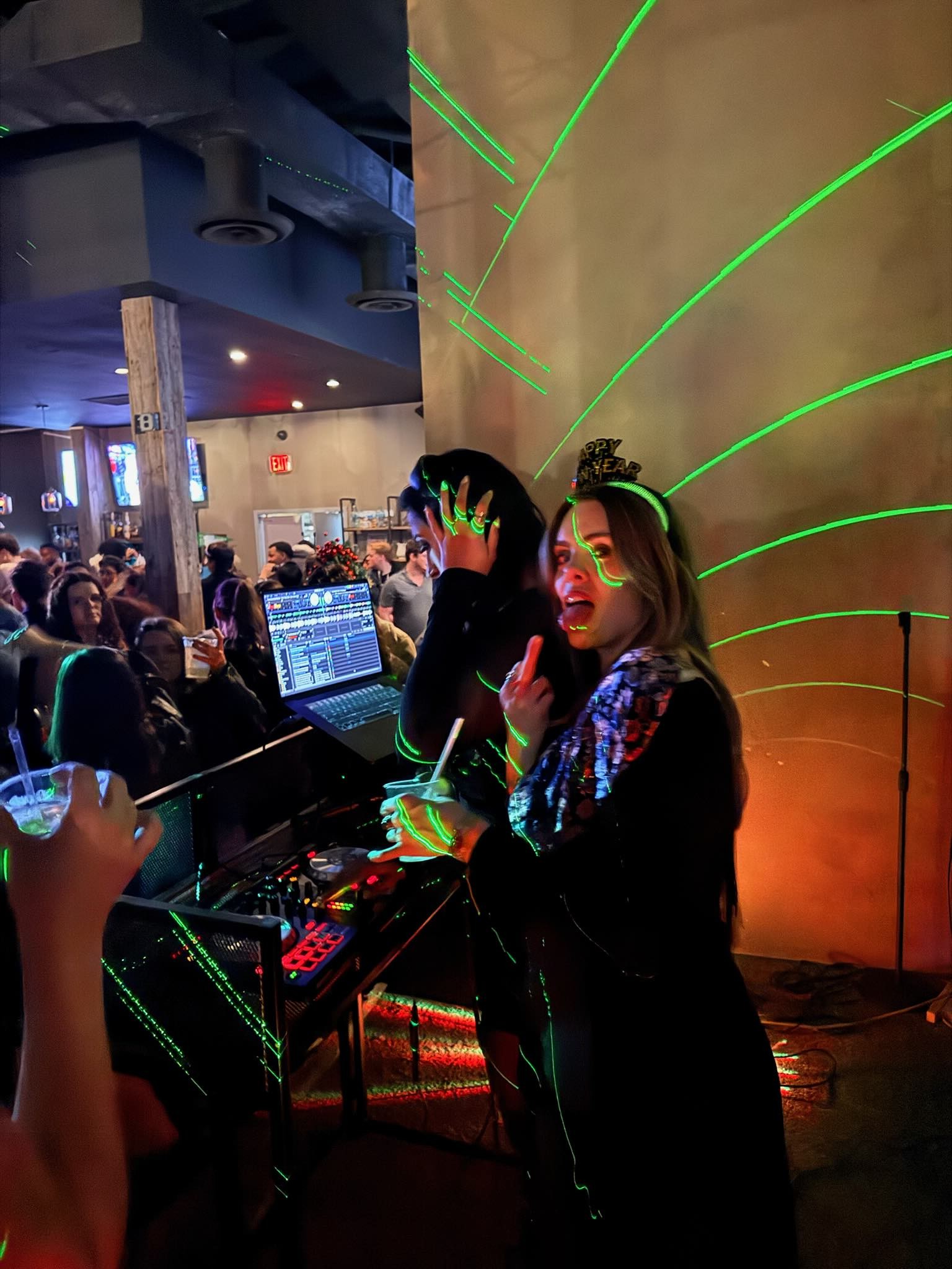 DJ Xhama performing a New Year’s Eve set under green lasers